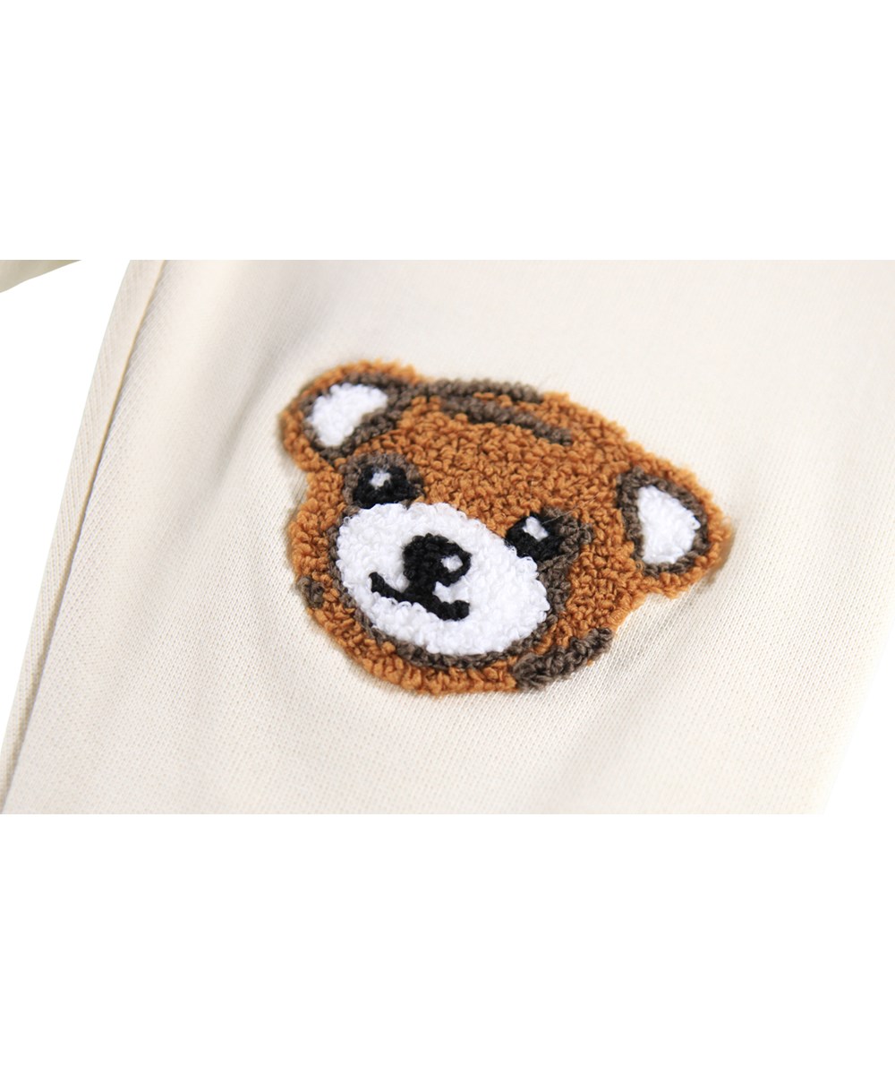 Simeon - White Noise - Zachte broek voor de kleintjes gemaakt van biologisch katoen. De broek is gebroken wit met zachte bruine teddyberen op de knieën.