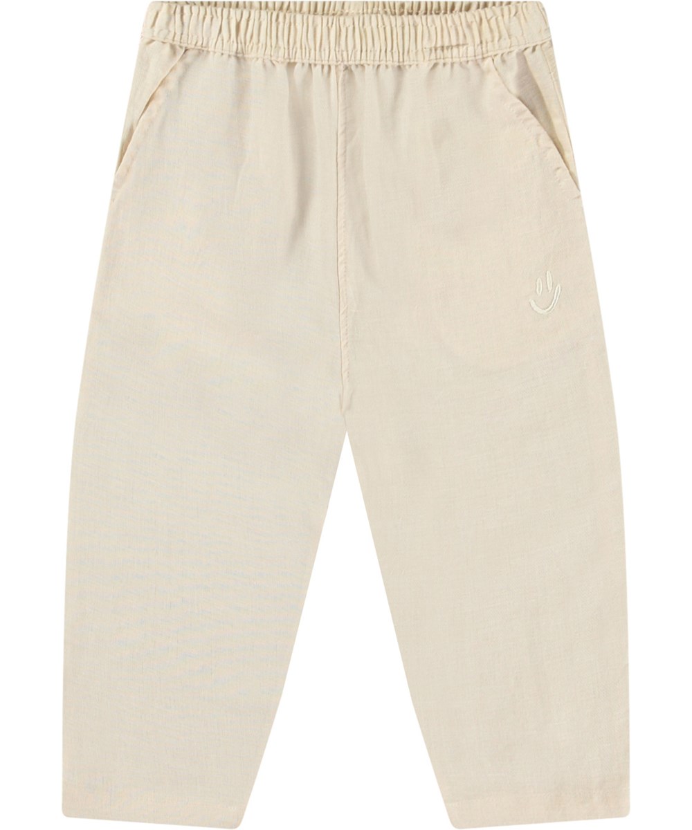 Sois - Summer Sand - Babybroek van biologisch katoen. De broek is beige met een kleine geborduurde smiley bij de zak.