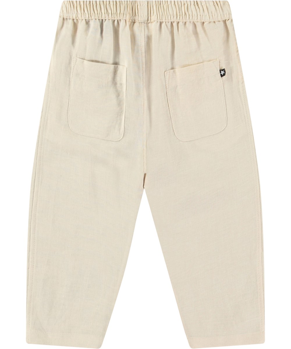 Sois - Summer Sand - Babybroek van biologisch katoen. De broek is beige met een kleine geborduurde smiley bij de zak.