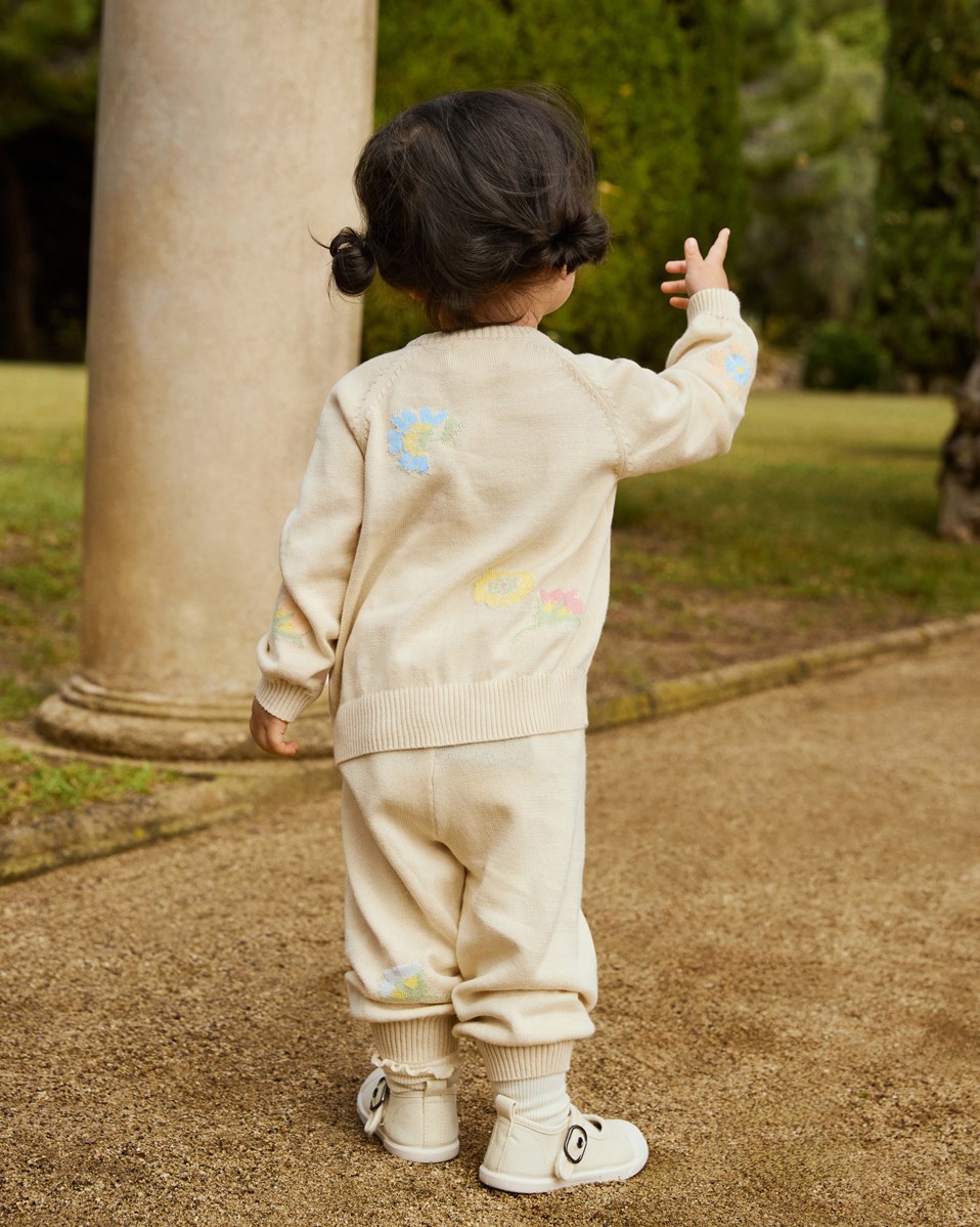 Sol - Pastel Flora - Gebreide babybroek van biologisch katoen. Het is lichtbeige met mooie bloemen