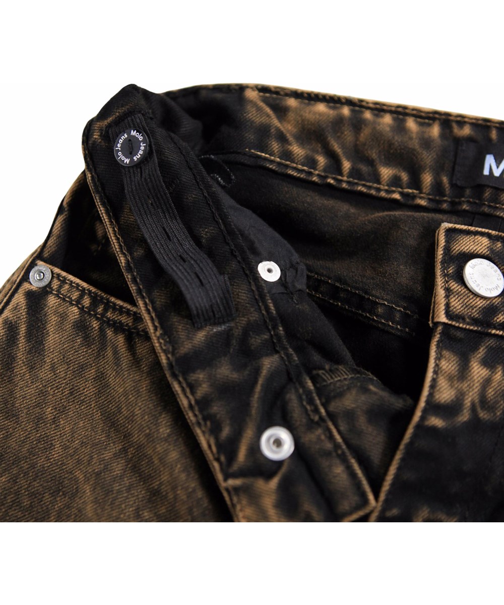 Aiden - Fawn Overdye - Denimjeans til børn lavet af økologisk bomuld med en sort og rød vask.