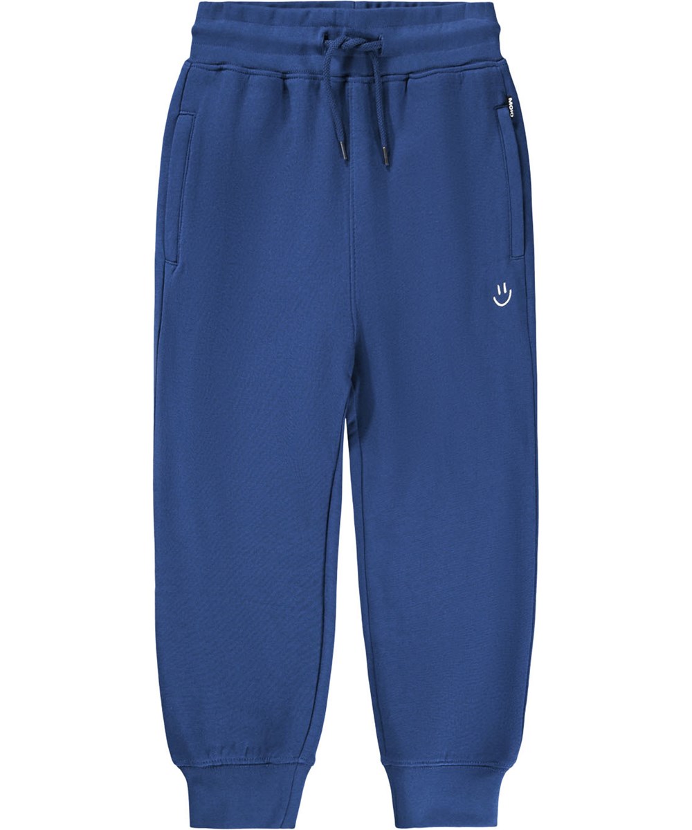 Alvar - Blue Depths - Blå sweatpants i økologisk bomuld med broderet hvidt smilende ansigt.