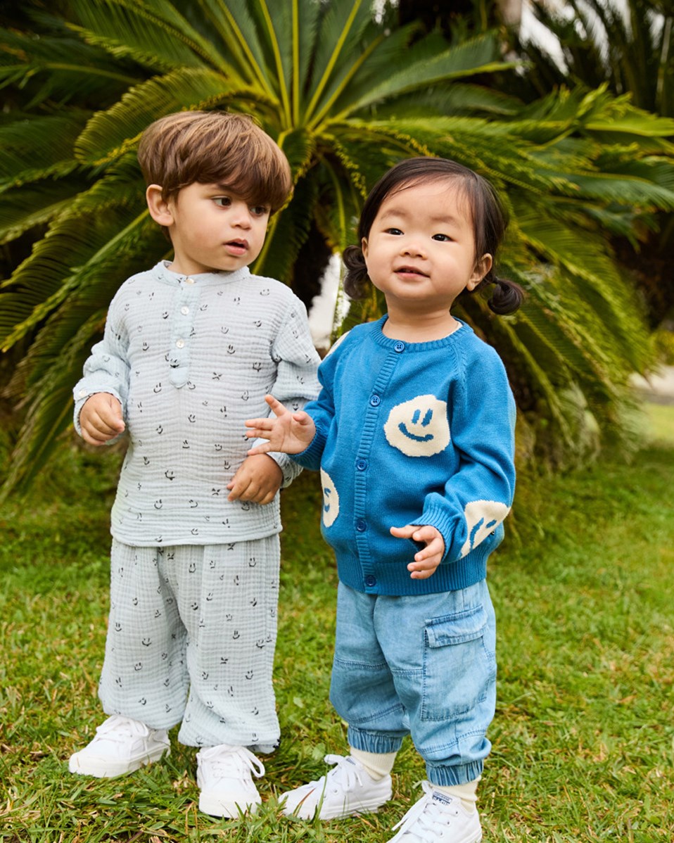 Enoz - Moods - Shirt aus Öko-Kräuselbaumwolle für Babys. Das Shirt zeigt ein Muster lächelnder Gesichter.