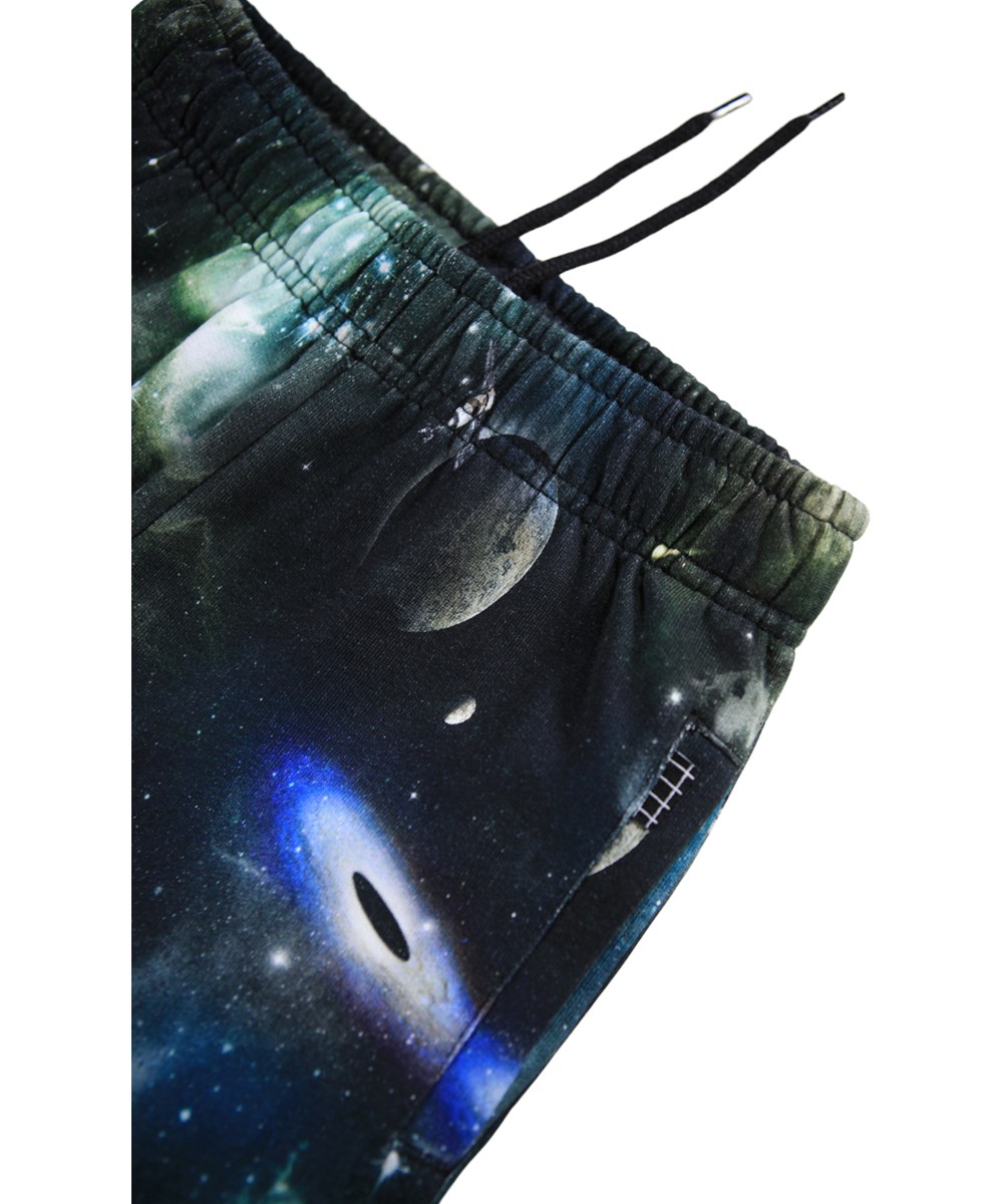 Adani - Deep Space - Bunte Jogginghosen für Kinder aus Öko-Baumwolle mit einem Aufdruck vom Leben im Weltraum.