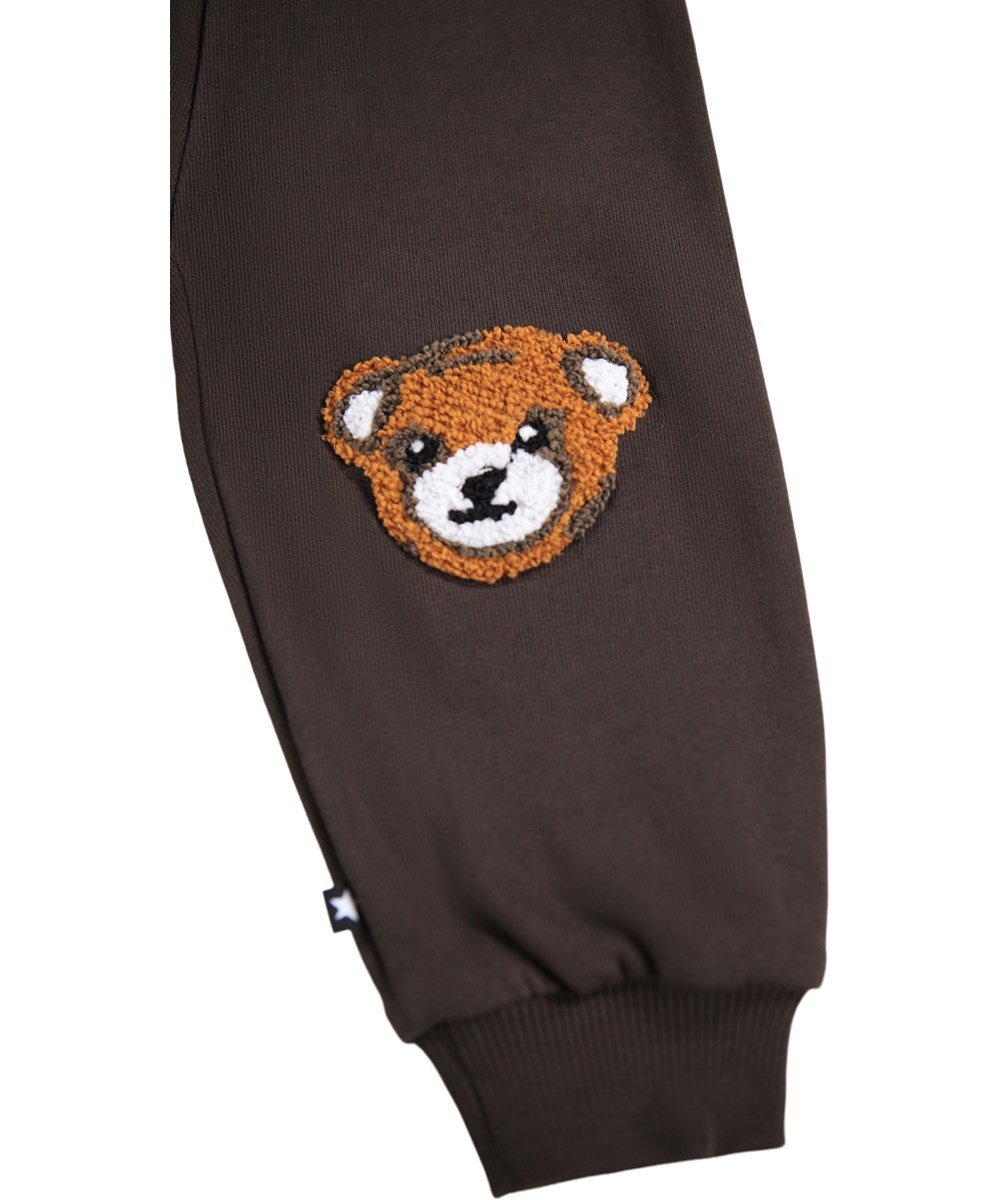 Simeon - Dark Cocoa - Weiche Hosen für die Kleinen aus Öko-Baumwolle. Die Hosen sind dunkelbraun mit weichen braunen Teddybären auf den Knien.