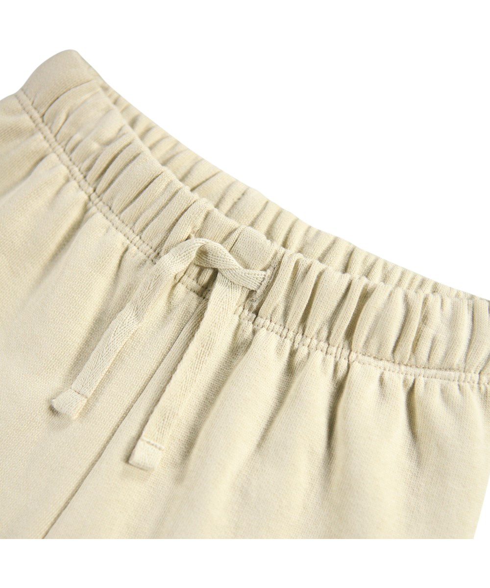 Simeon - Dog Play - Weiche beige Hosen für die Kleinen aus Öko-Baumwolle mit einem Dackel-Print.