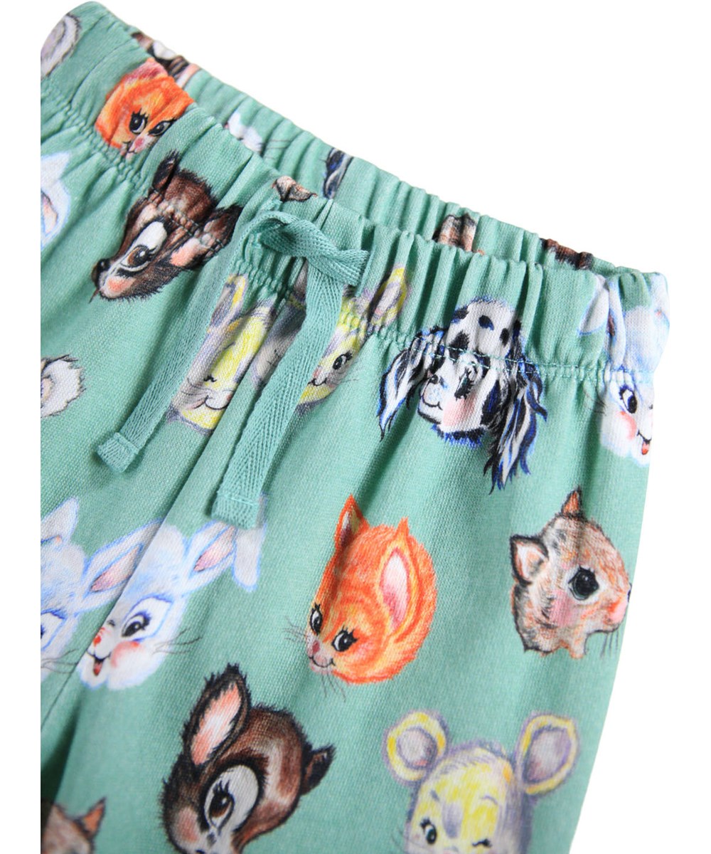 Simeon - Itty Bitty - Weiche grüne Hosen für die Kleinen aus Öko-Baumwolle mit einem Aufdruck von illustrierten Tieren.