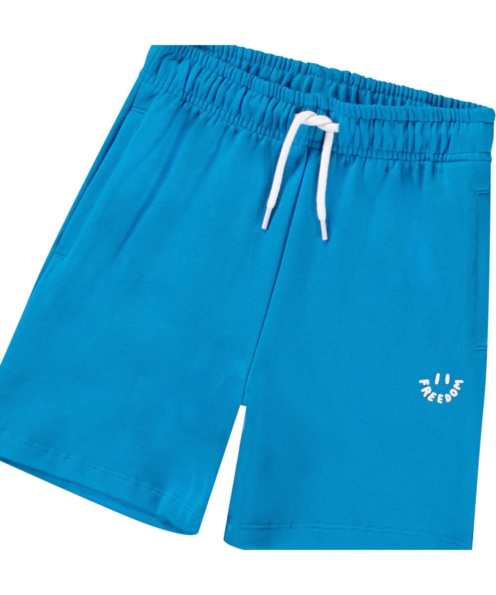 Adian - Peacock Blue - Blauwe biologisch katoenen joggingshort voor kinderen.