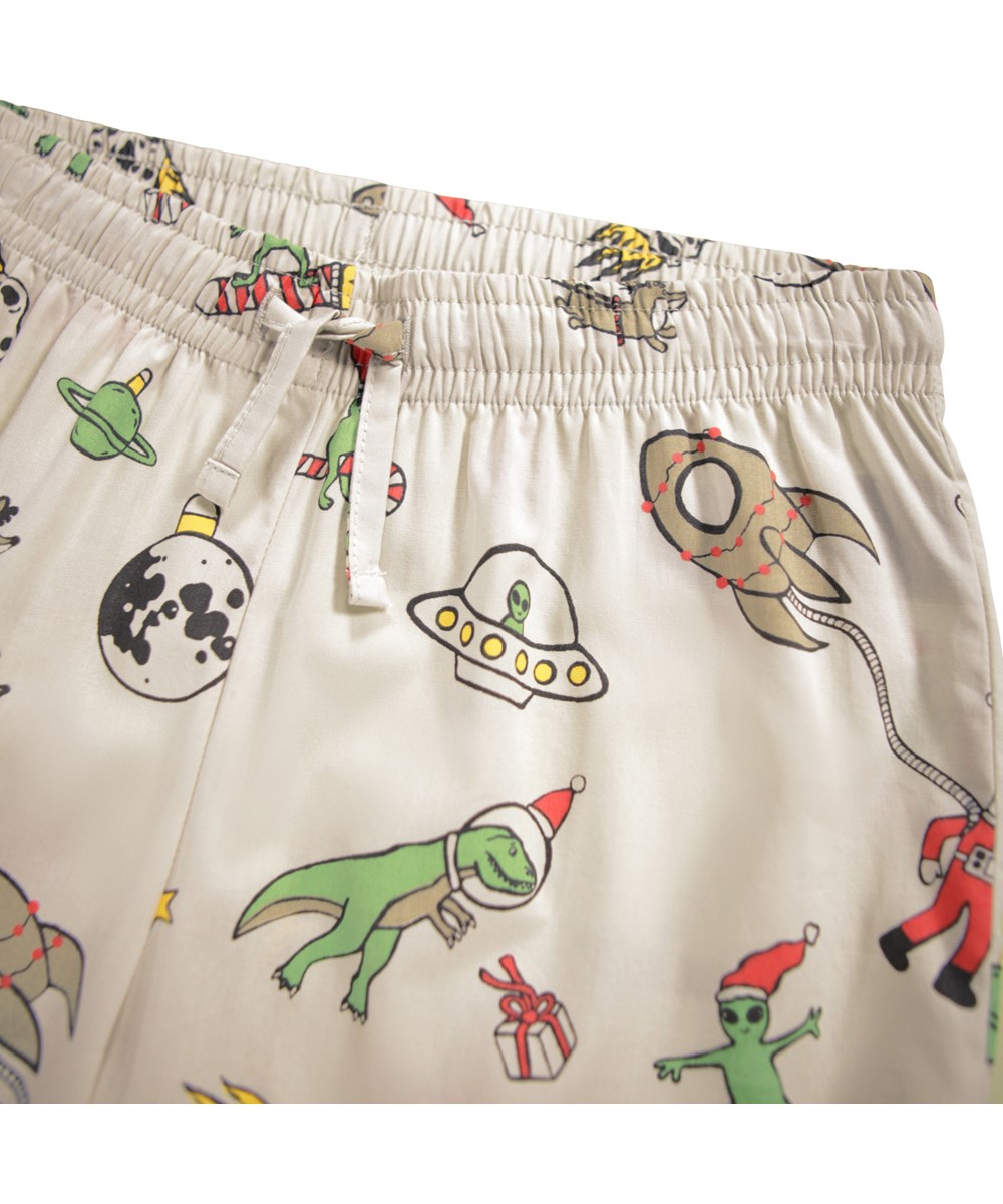 Lex - Spacy Nights - Beige kinderpyjama gemaakt van biologisch katoen met een kerst in de ruimte print.