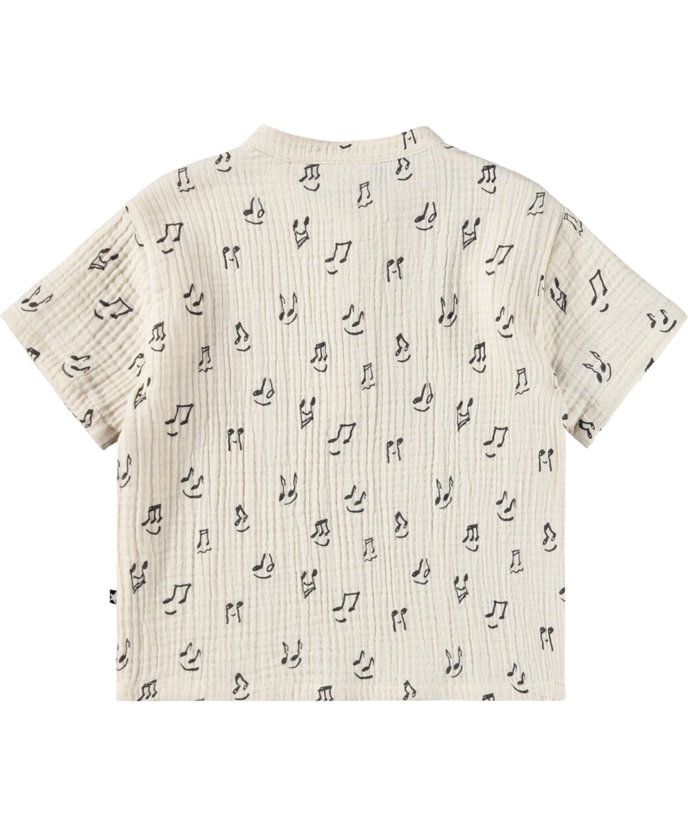 Evero - Happy Notes - Crèmekleurig, kort mouwloos poloshirt voor de kleintjes, gemaakt van biologisch katoenen mousseline met een muziekprint.