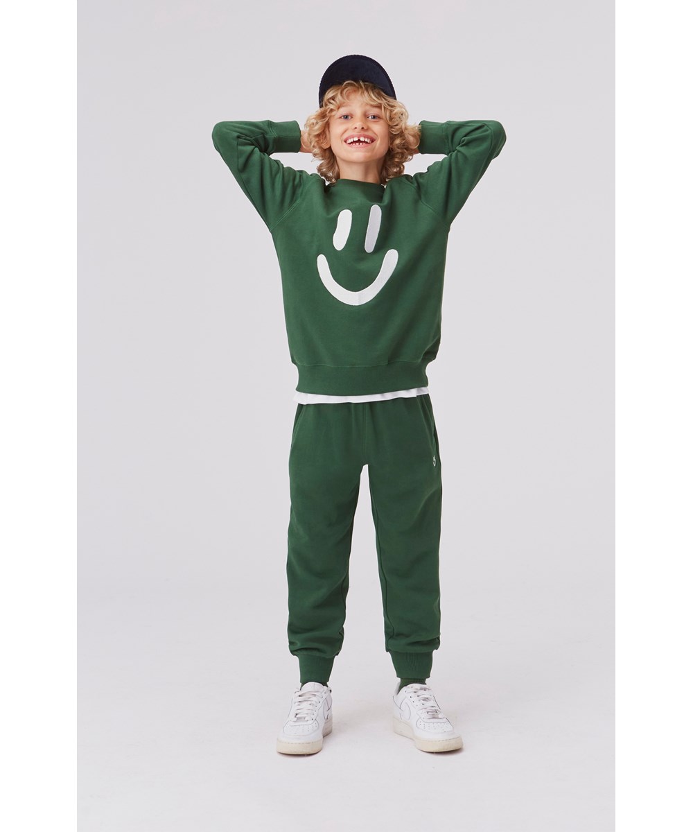 Alvar - Eden - Green organic sweatpants with smiley face
