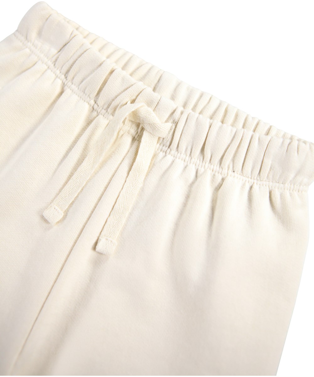 Simeon - Croco-Phant - Soft off-white pants for the little ones made of organic cotton with a handprint of colorful animals.