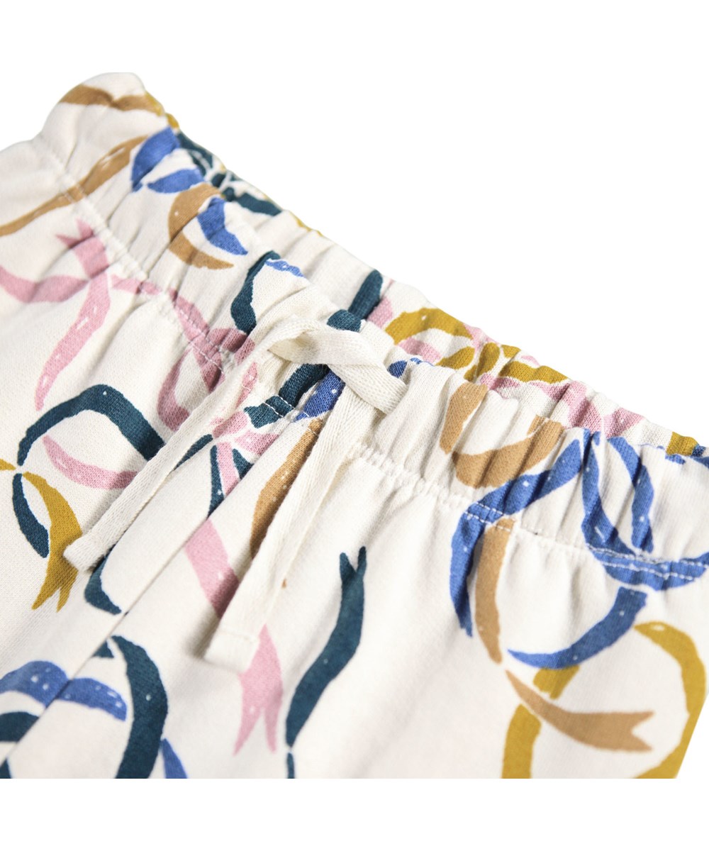 Simeon - Festivity Bows - Soft off-white pants for the little ones made of organic cotton with a print of colorful bows.