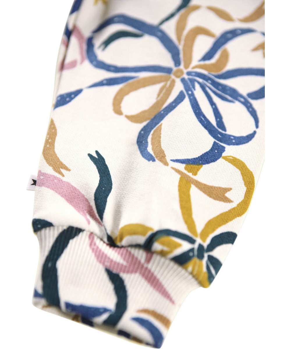 Simeon - Festivity Bows - Soft off-white pants for the little ones made of organic cotton with a print of colorful bows.