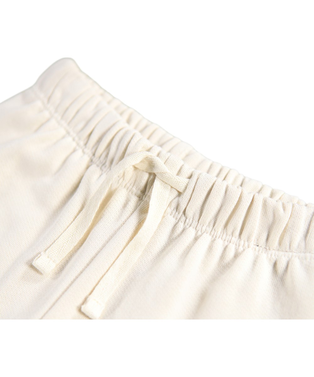 Simeon - White Noise - Soft pants for the little ones made of organic cotton. The pants are off-white with soft brown teddy bears on the knees.