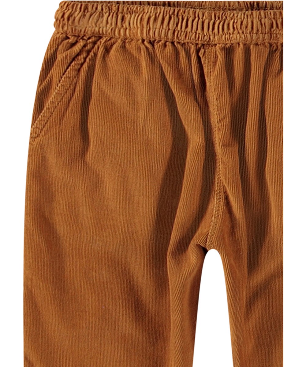 Sois - Brown Sugar - Orange organic cotton baby trousers with loose fit and elastic waistband.