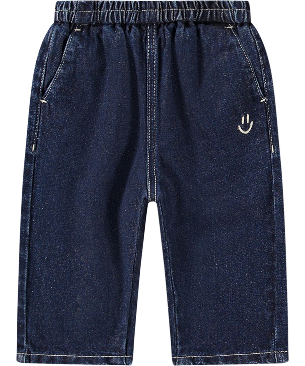 Sois - Oceanic Denim - Blue denim trousers for kids with loose fit, elastic waist, and pockets. Lightweight and airy with embroidered smiling face.