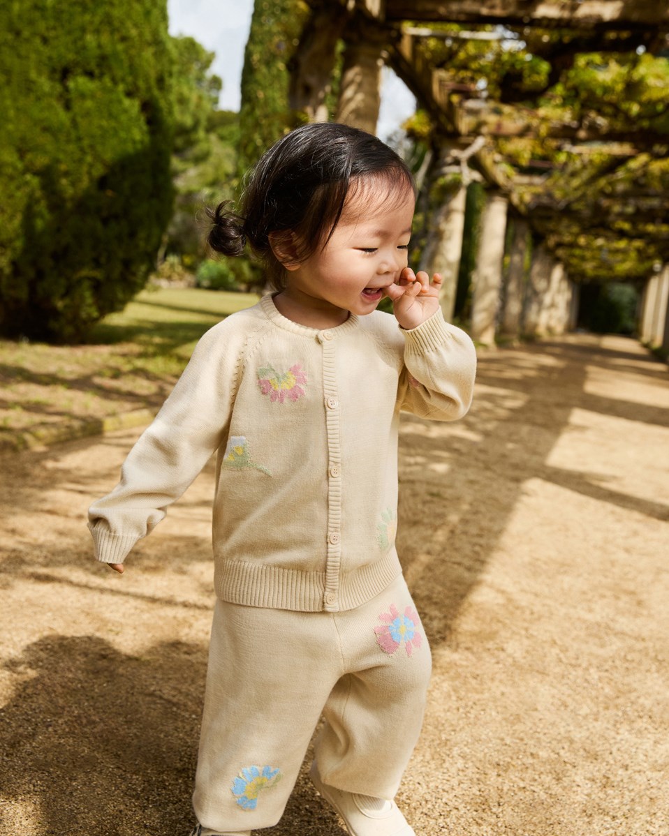 Sol - Pastel Flora - Knitted pants in organic cotton for baby. Knitted in light beige adorned with delicate flowers.