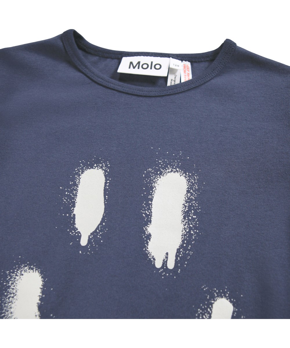 Lue - Galaxy Blue - Dunkelblaues Pyjama-Set für Kinder aus Öko-Baumwolle mit einem weiß aufgesprühten Lächeln.