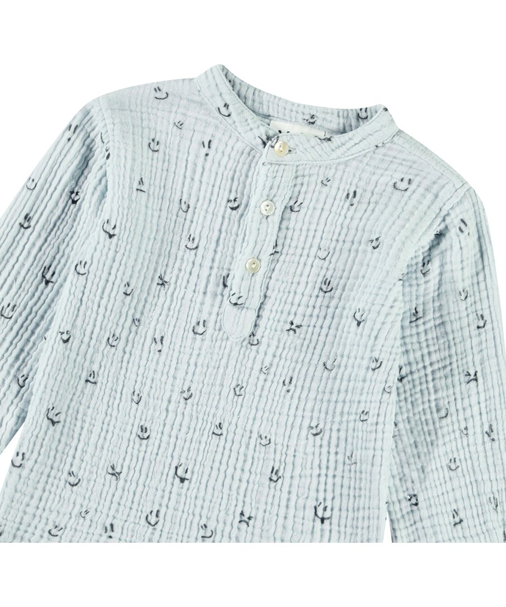 Enoz - Moods - Shirt in organic crinkled cotton for babies. The shirt features a print of smiling faces.