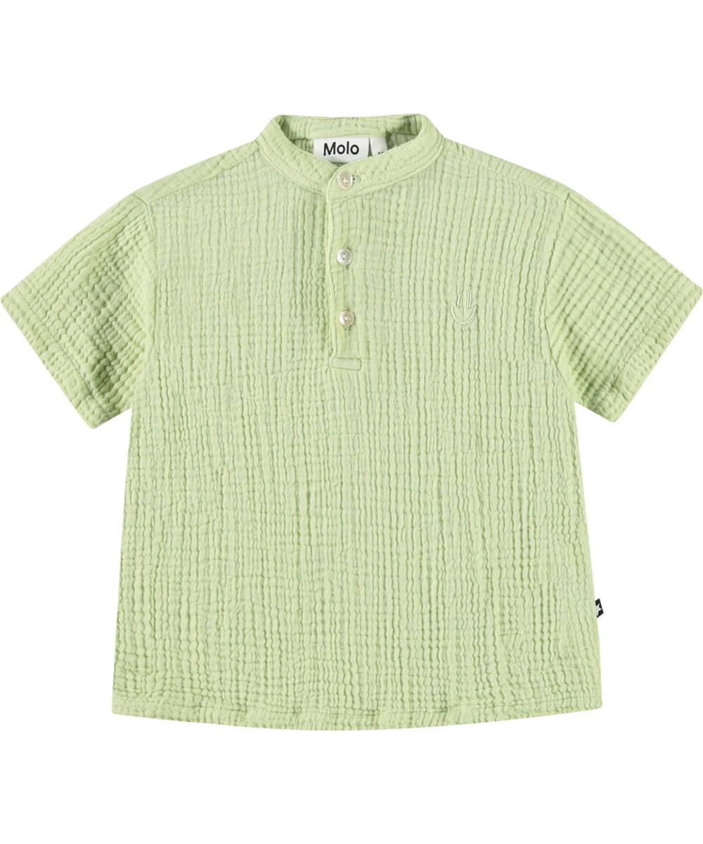 Ever - Misty Green - Short-sleeved shirt with buttons in organic crinkled cotton for a baby. The shirt is light green with a small embroidered smiling face.