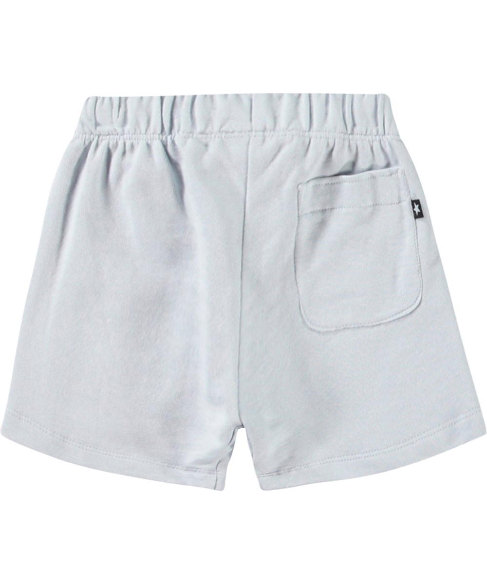 Simms - Skywriting - Soft shorts in organic cotton for baby. These shorts are light blue with an embroidered smiling face on one leg.