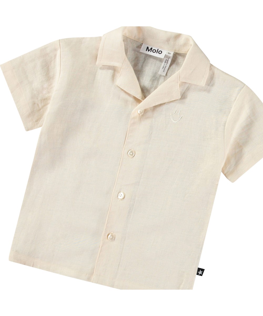 Eyou - Summer Sand - Kortærmet skjorte i økologisk bomuld til baby. Skjorten er beige med broderet smilende ansigt.