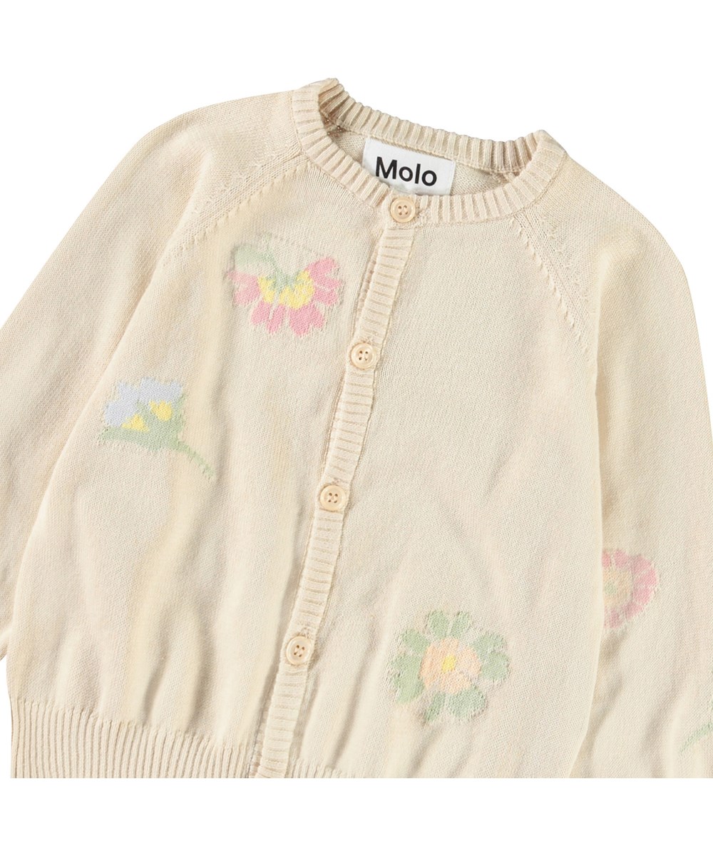 Brody - Pastel Flora - Knitted cardigan for baby in soft organic cotton. The cardigan is beige with flowers.