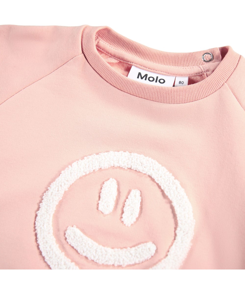 Disc - Rose Cloud - Pink sweatshirt for the little ones made of soft organic cotton with an embroidered smiling face on the front.