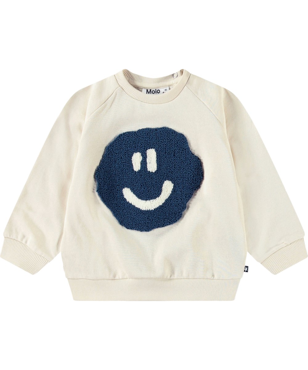 Disc - Summer Sand - Organic beige baby sweatshirt with a soft smiling face in blue.