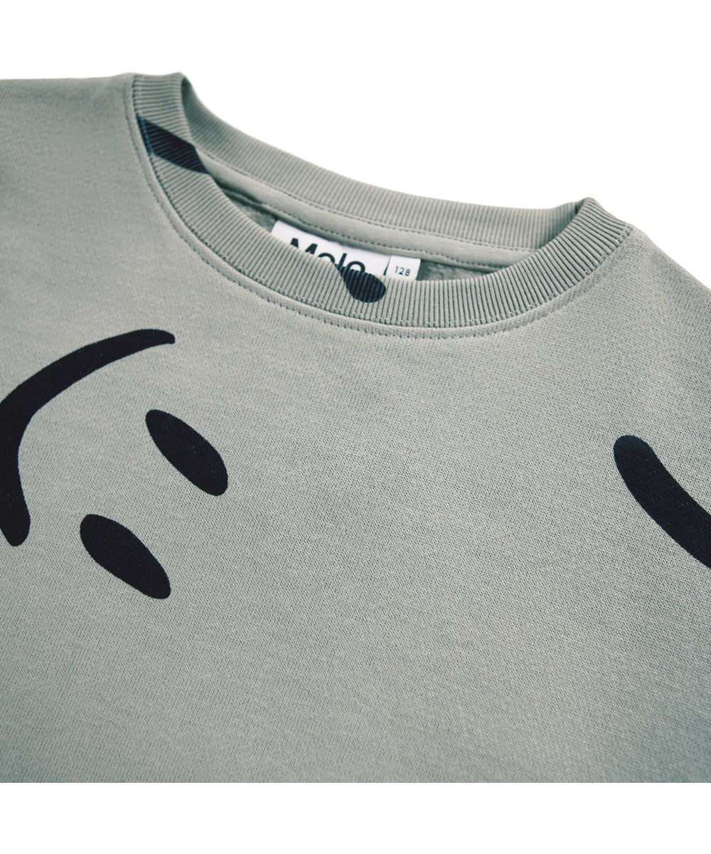 Monti - Big Smiles Fall - Beige sweatshirt for children made of soft organic cotton with a print of smiling faces.