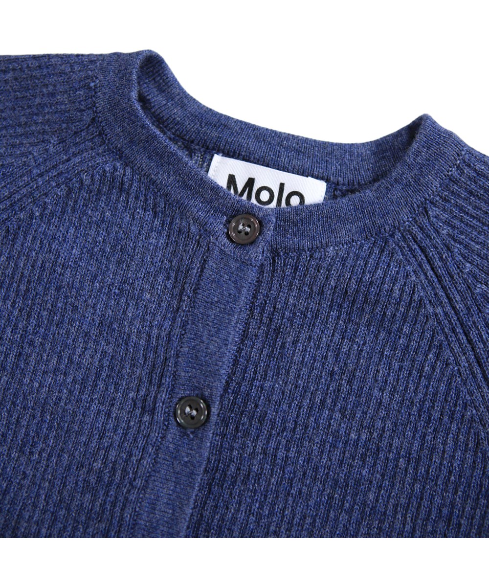 Basta - Evening Sky - Dunkelblauer Strick-Cardigan für die Kleinen aus einer weichen Baumwoll- und Wollmischung mit einem lächelnden Gesicht auf der Rückseite.