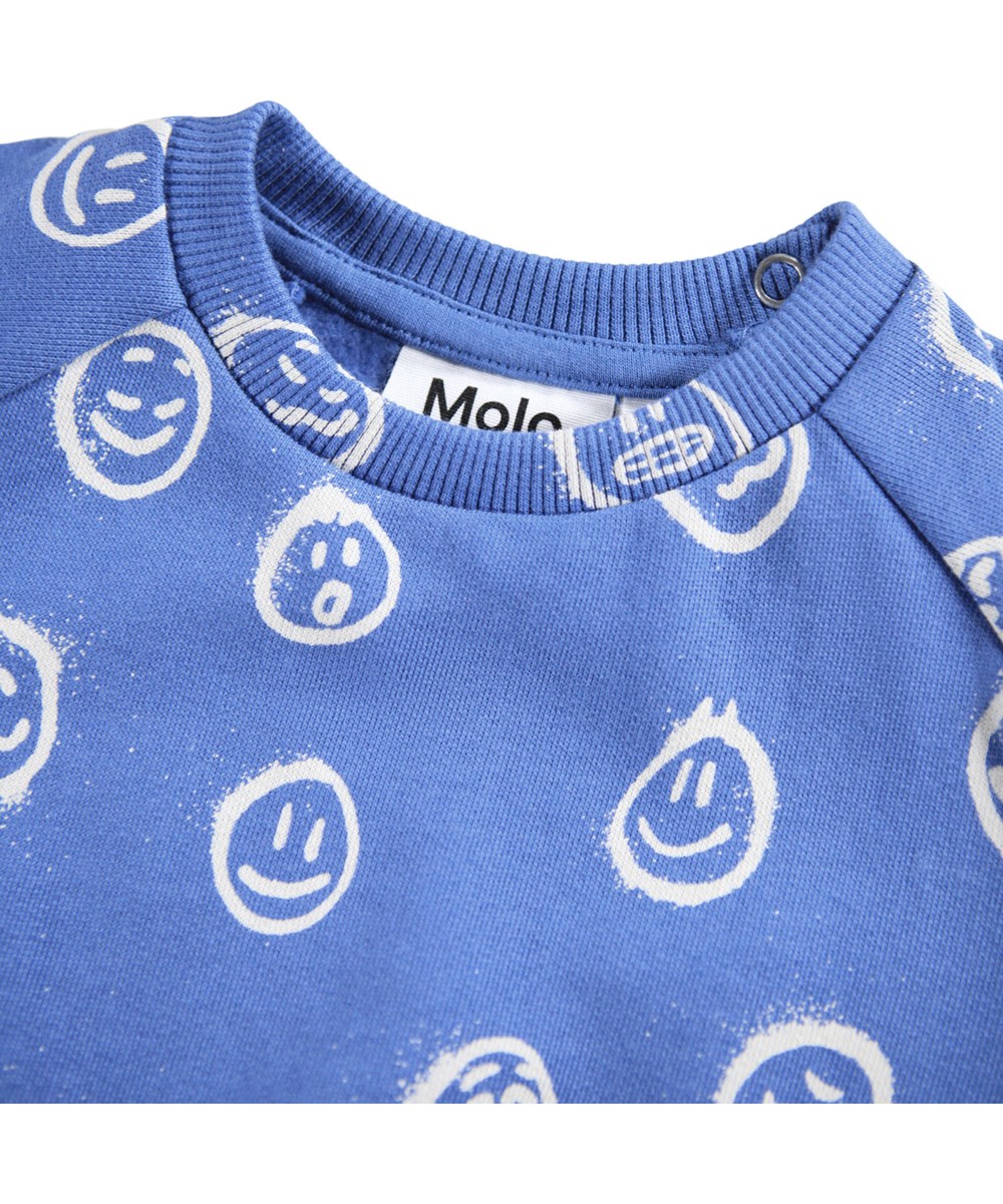 Disc - Blue Moods - Blaues Sweatshirt für die Kleinen aus weicher Öko-Baumwolle mit einem Aufdruck von Gesichtern in verschiedenen Stimmungen.