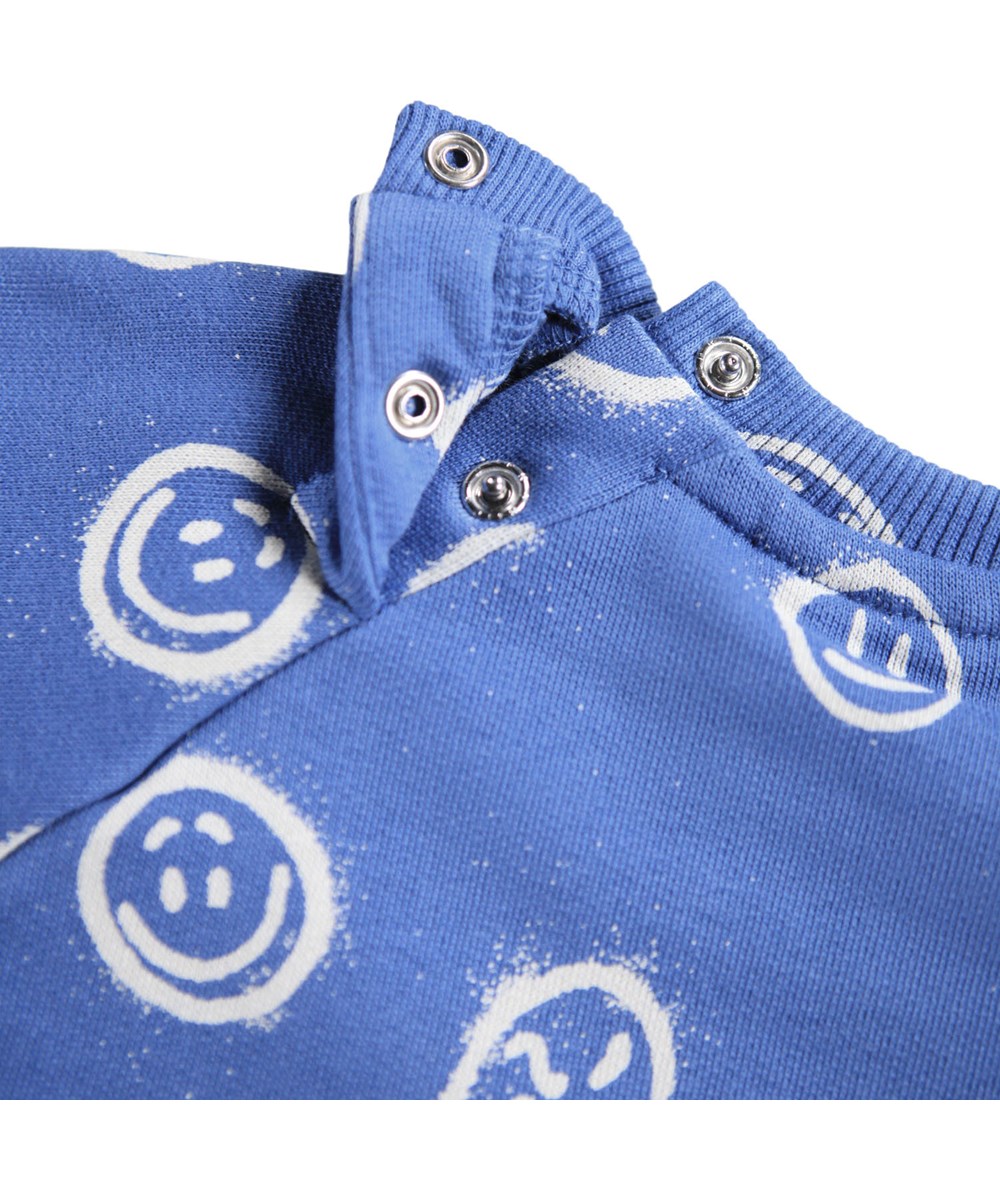 Disc - Blue Moods - Blaues Sweatshirt für die Kleinen aus weicher Öko-Baumwolle mit einem Aufdruck von Gesichtern in verschiedenen Stimmungen.
