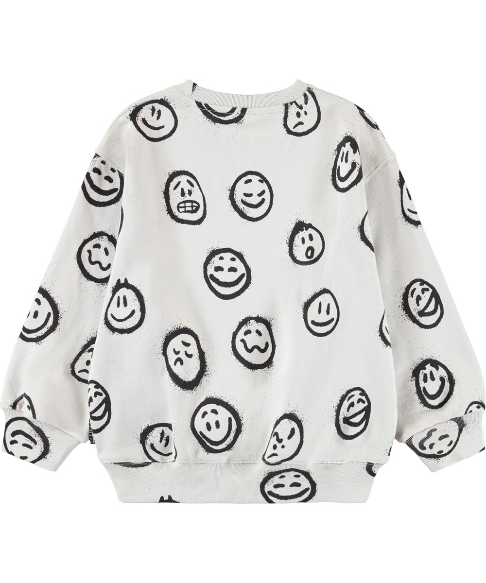 Monti - Different Moods - Off-White-Sweatshirt für Kinder aus weicher Öko-Baumwolle mit einem Druck von Gesichtern in verschiedenen Stimmungen.