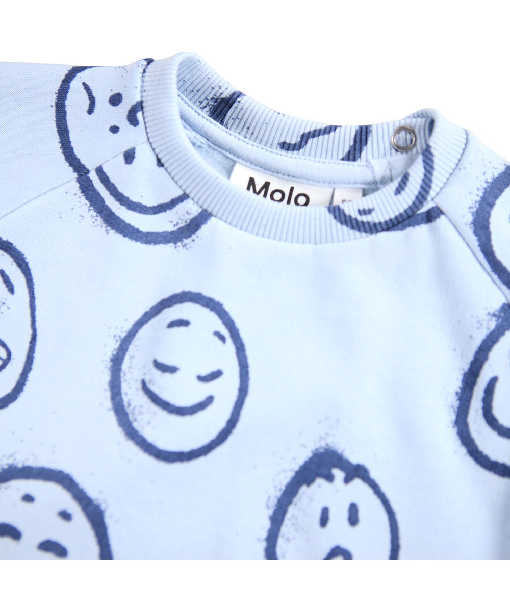 Disc - Blue Moon Moods - Lichtblauwe sweater voor de kleintjes gemaakt van zacht biologisch katoen met een print van gezichten in verschillende stemmingen.