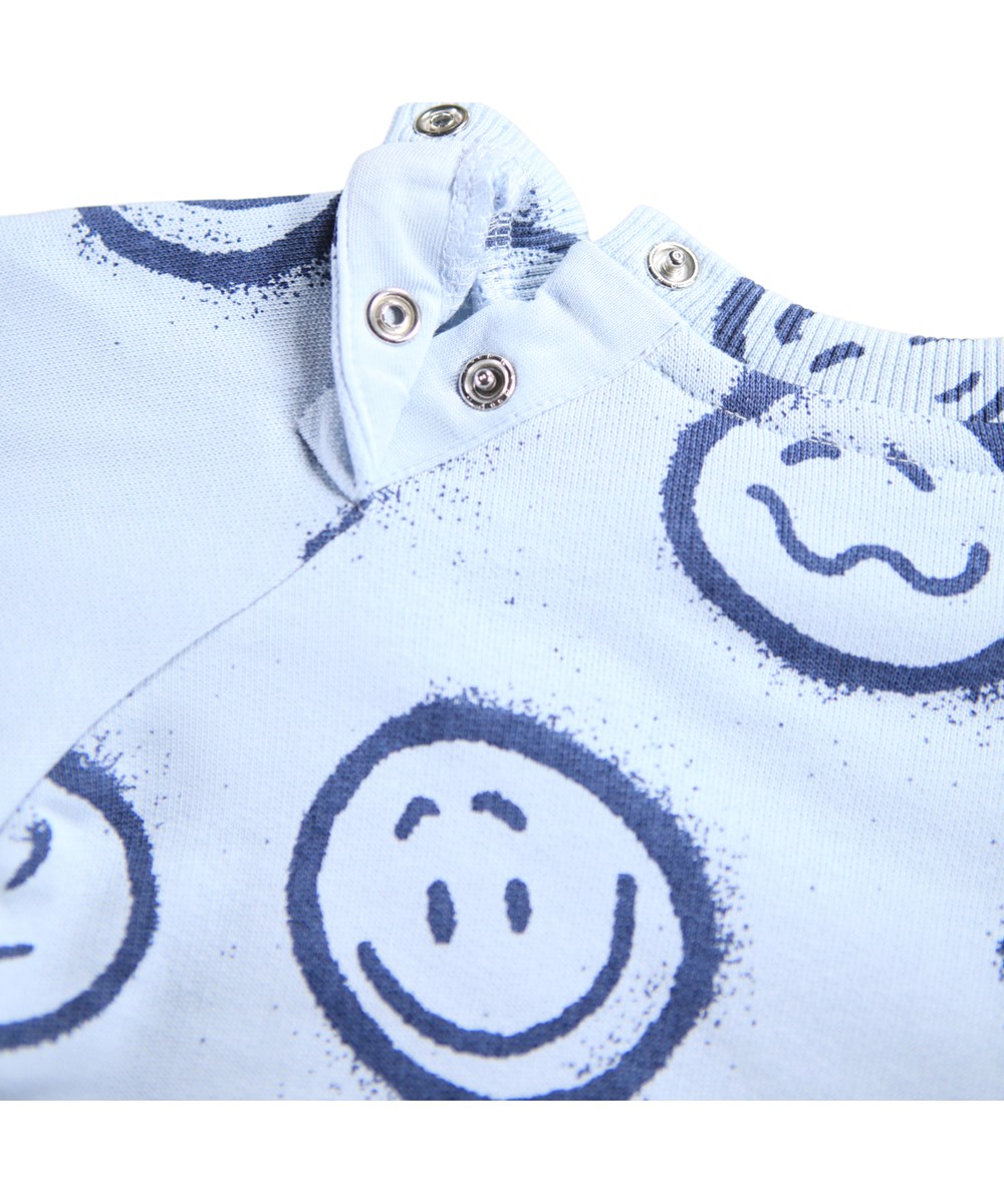 Disc - Blue Moon Moods - Lichtblauwe sweater voor de kleintjes gemaakt van zacht biologisch katoen met een print van gezichten in verschillende stemmingen.