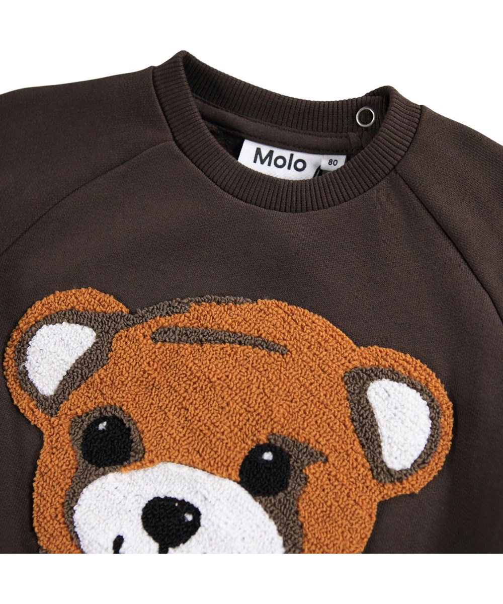 Disc - Dark Cocoa - Donkerbruine sweater voor de kleintjes gemaakt van zacht biologisch katoen met op de voorkant een geborduurd teddyberengezicht.