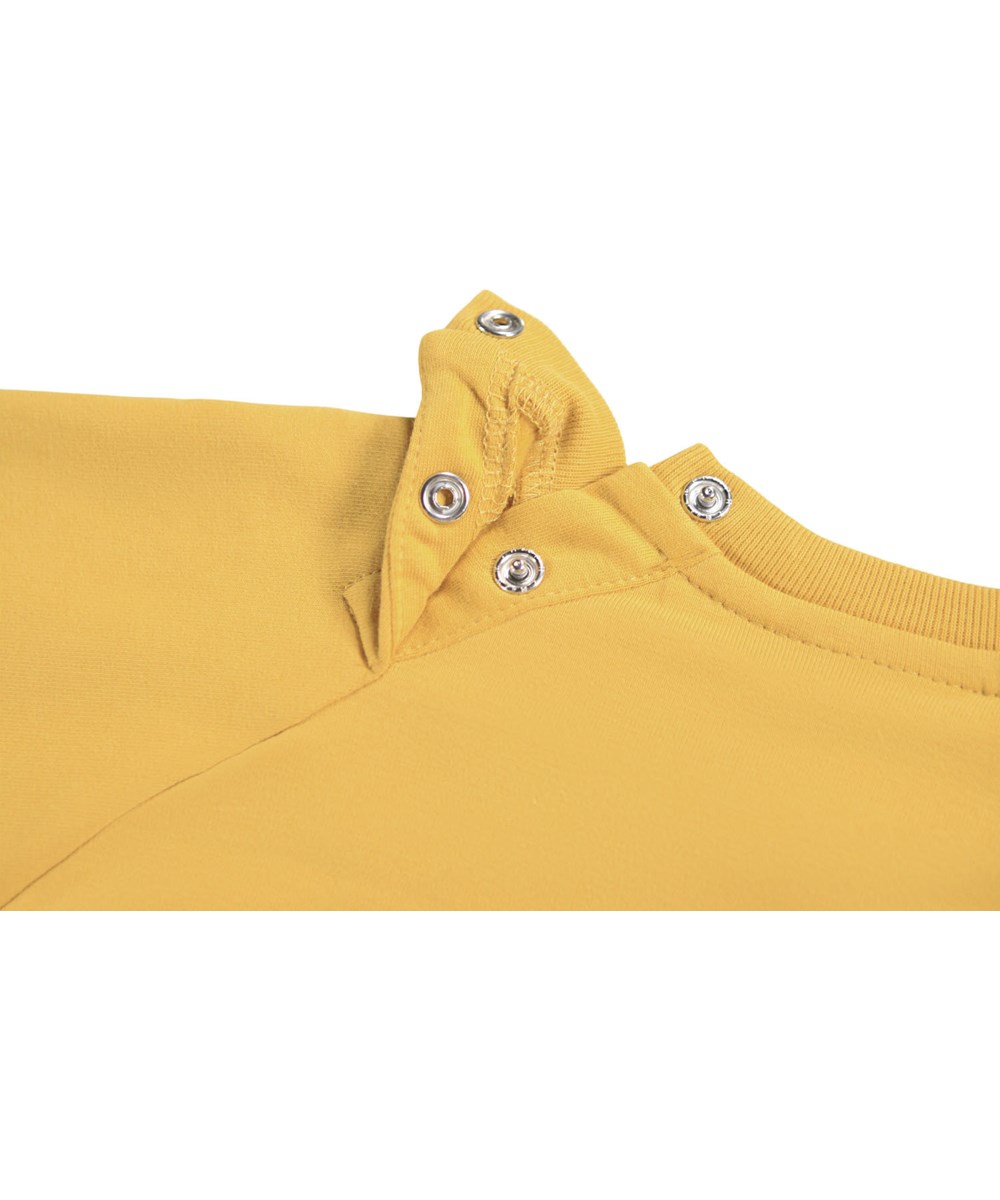 Disc - Energy - Gele sweater voor de kleintjes gemaakt van zacht biologisch katoen met op de voorkant een geborduurd lachend gezicht.