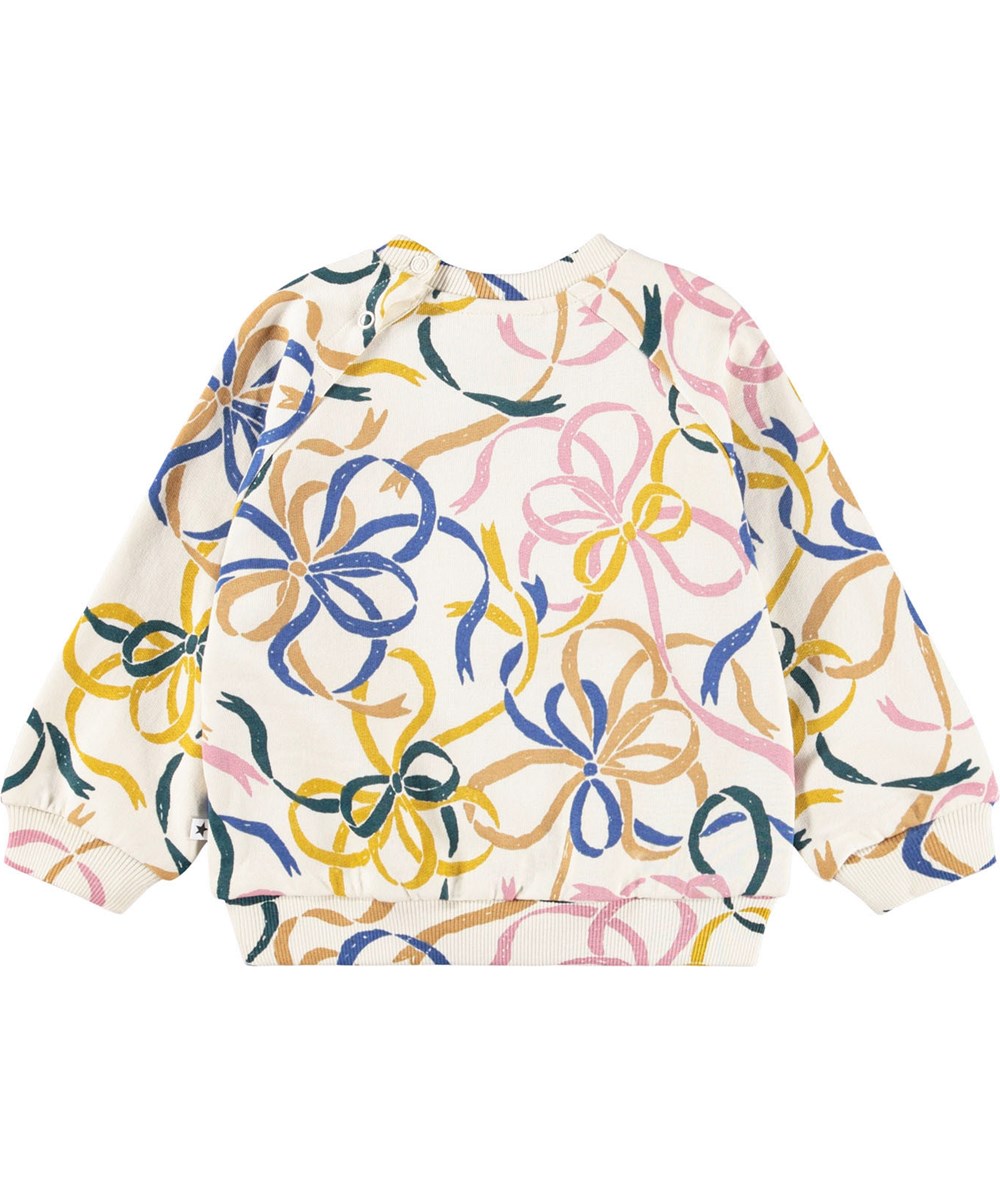 Disc - Festivity Bows - Gebroken witte sweater voor de kleintjes gemaakt van zacht biologisch katoen met een print van kleurrijke linten.