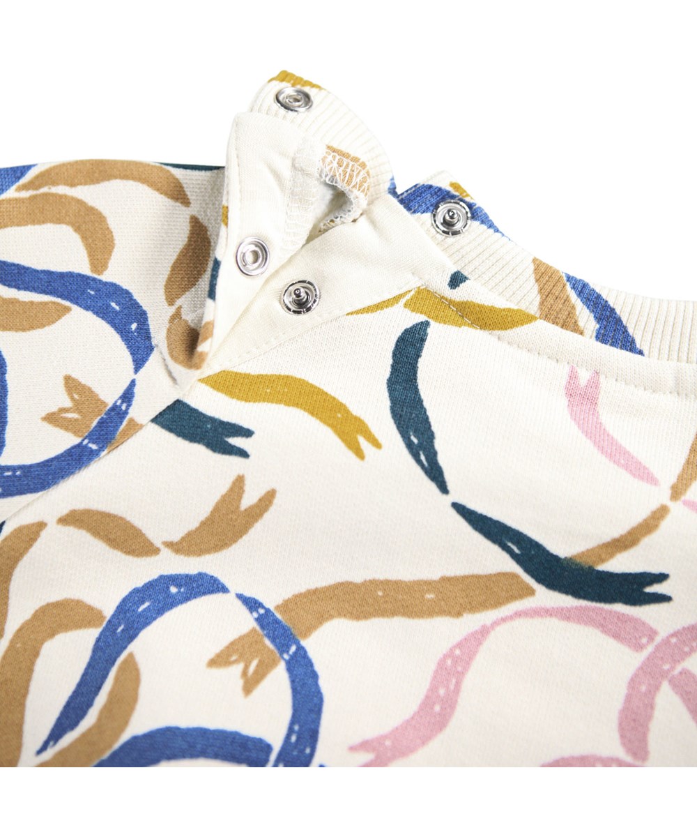 Disc - Festivity Bows - Gebroken witte sweater voor de kleintjes gemaakt van zacht biologisch katoen met een print van kleurrijke linten.