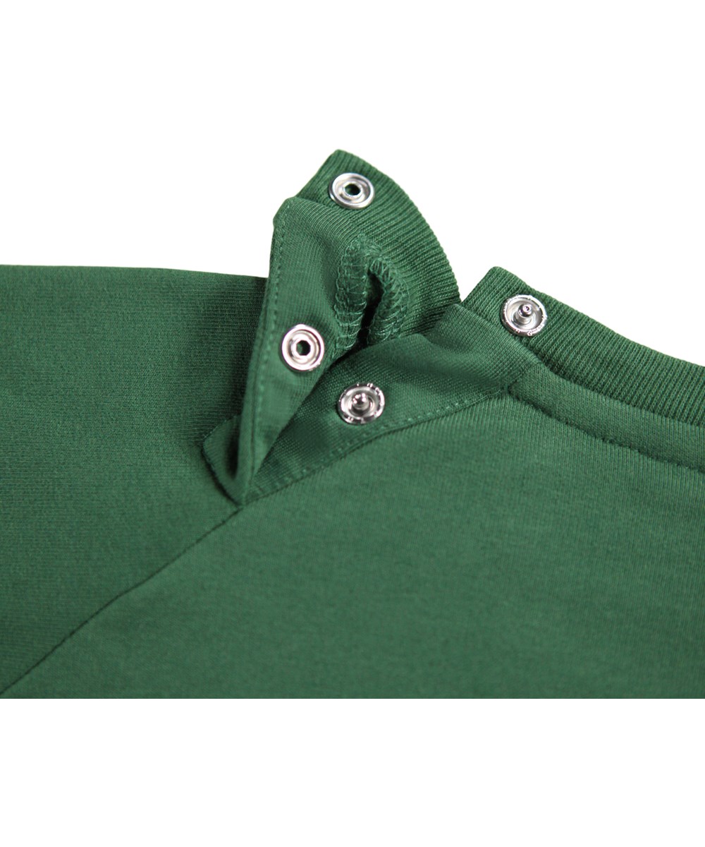 Disc - Pine Tree - Donkergroene sweater voor de kleintjes gemaakt van zacht biologisch katoen met op de voorkant een geborduurd lachend gezicht.