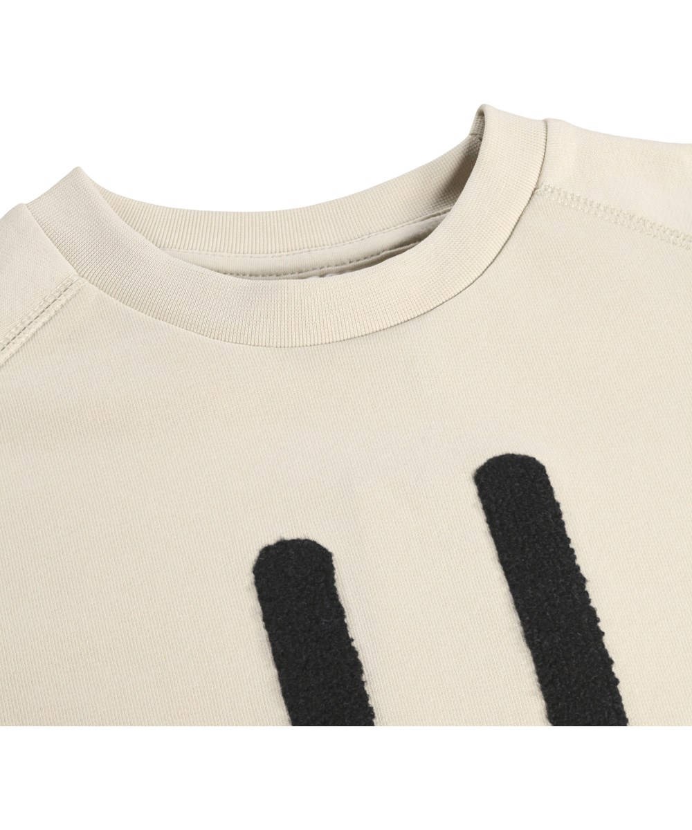 Mike - Summer Sand - Beige kindersweater met een geborduurde lach gemaakt van biologisch katoen 