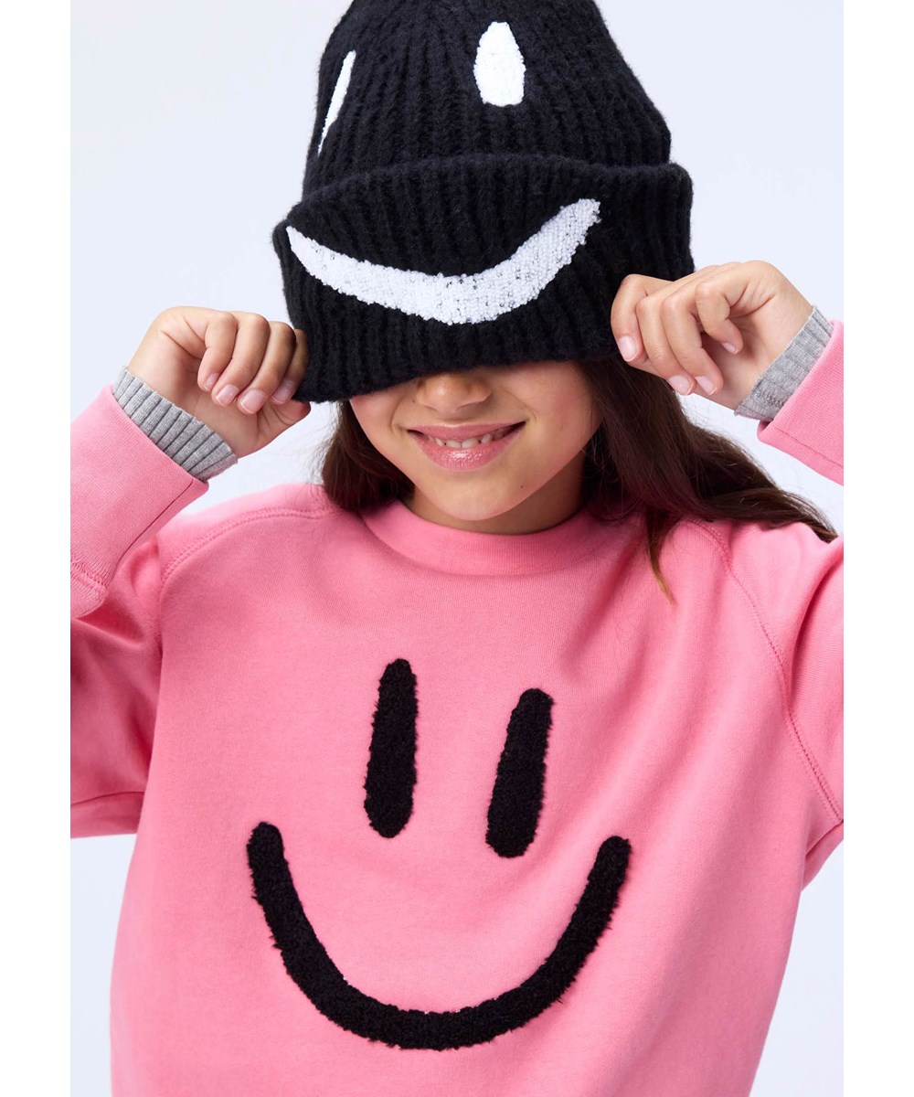 Mike - Confetti - Roze kindersweater gemaakt van zacht biologisch katoen met raglanmouwen en ribboorden rond de hals, mouwen en taille.