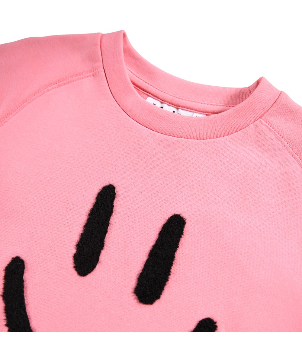 Mike - Confetti - Roze kindersweater gemaakt van zacht biologisch katoen met raglanmouwen en ribboorden rond de hals, mouwen en taille.