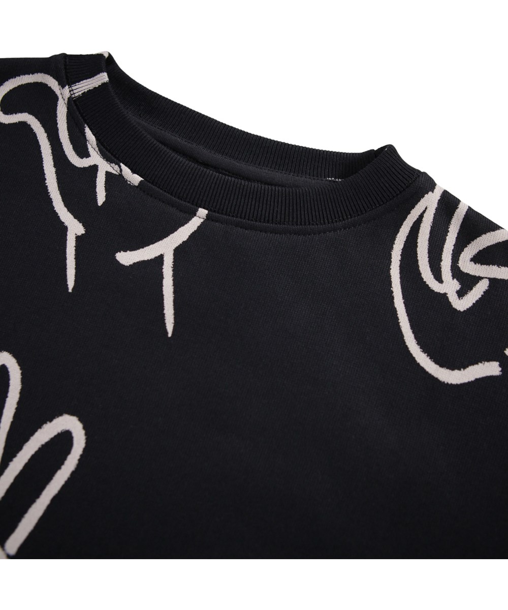 Monti - Drawn Hands - Zwarte kindersweater gemaakt van zacht biologisch katoen met een met de hand getekend ontwerp.