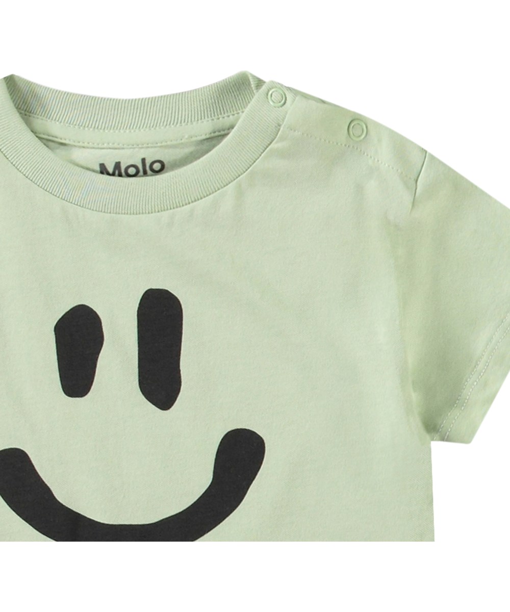 Enzo - Misty Green - Klassieke biologische katoenen baby t-shirt. Het t-shirt is lichtgroen met een smiley.