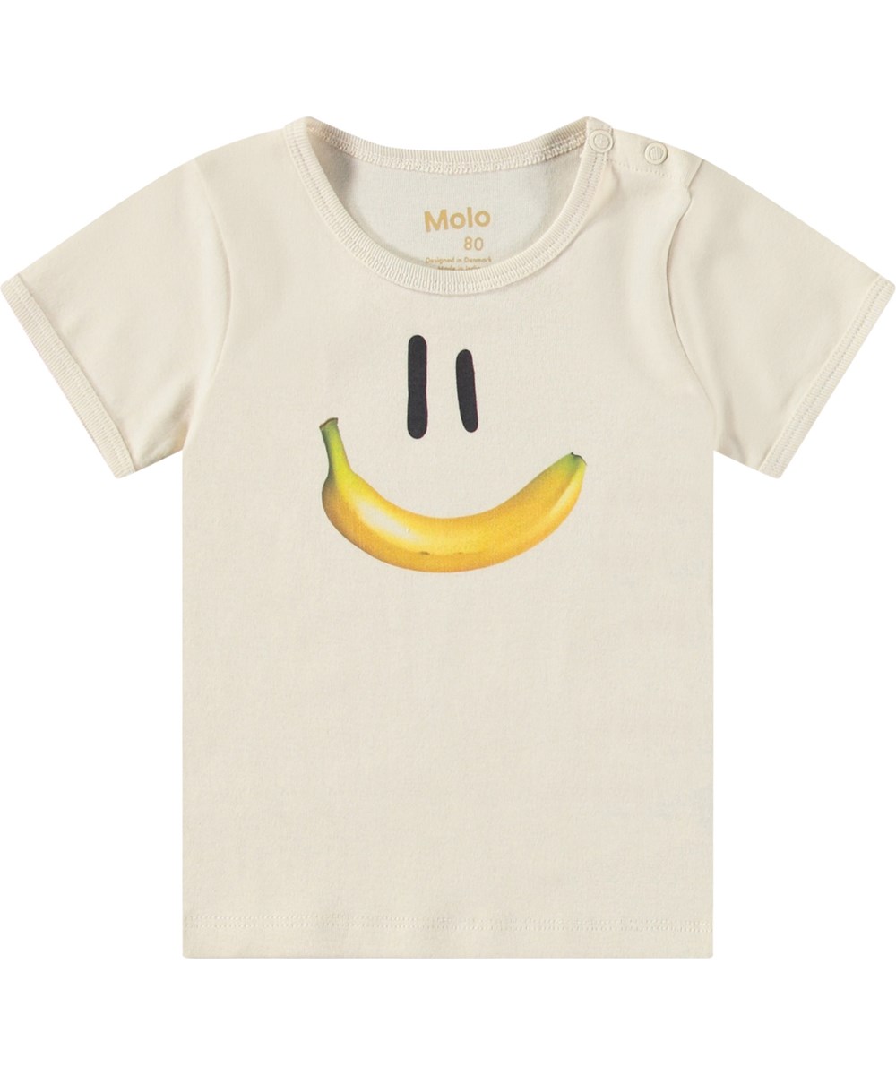 Easy - Babynanas Smile - Beiges Öko-Baumwoll-T-Shirt für Babys. Das T-Shirt hat eine enge Passform und zeigt ein lächelndes Gesicht mit einem Bananenmund.