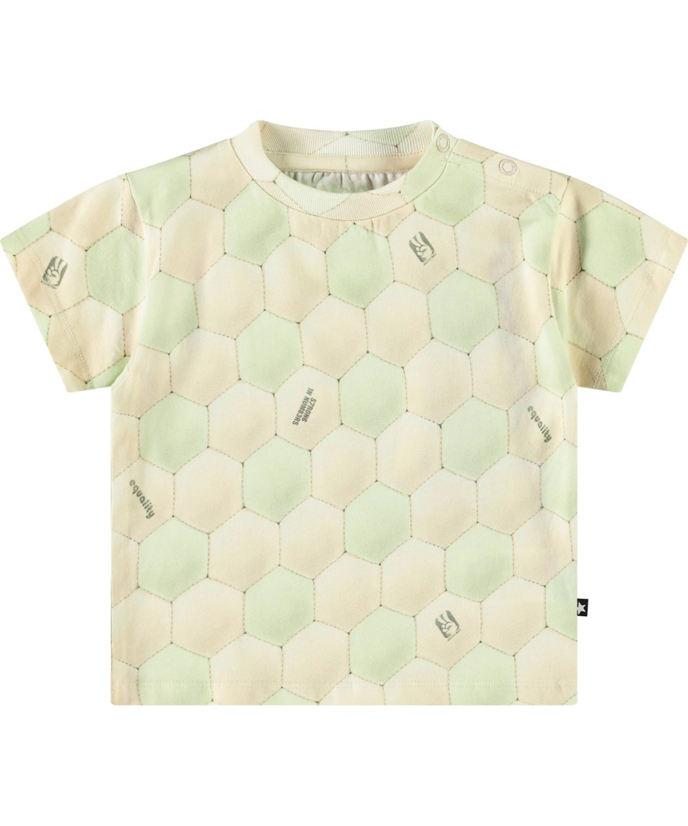 Enzo - Football Misty - Klassisches Öko-Baumwoll-T-Shirt für Babys. Das T-Shirt zeigt einen Druck einer Fußballoberfläche in Creme und Hellgrün.