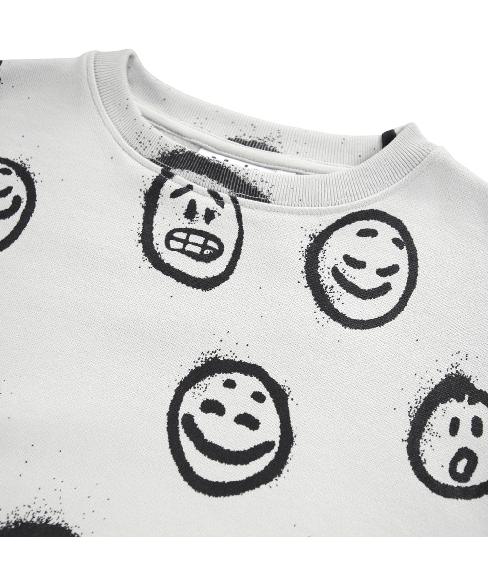 Monti - Different Moods - Råhvid sweatshirt til børn i blødt økologisk bomuld med print af ansigter i forskelligt humør.